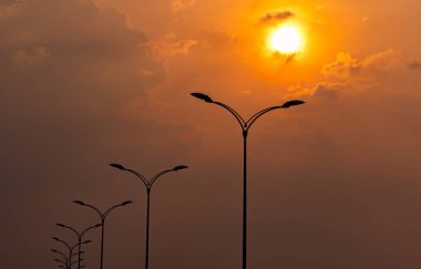 Güzel turuncu ve sarı günbatımı gökyüzü ve akşamları bulutlar ile Siluet sokak elektrik direği. Sokak lambası Lambası ışığı. Aydınlatma Güç ve enerji tasarrufu kavramı için Şehir yol lambası sonrası. 