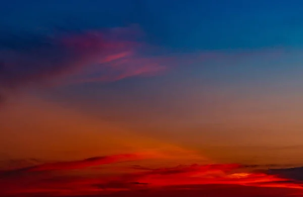 Dramatic red and blue sky and clouds abstract background. Red-blue clouds on sunset sky. Warm weather background. Art picture of sky at dusk. Sunset abstract background. Sad dramatic sunset sky.