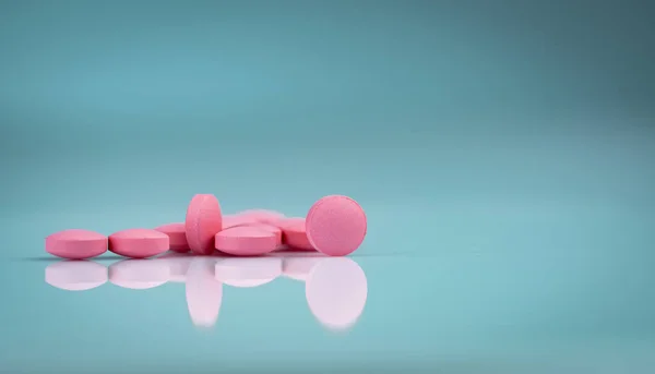 Runda rosa tabletter piller på gradient bakgrund. Vitaminer och mineraler plus folsyra vitamin E och zink i drog flaska på gradient bakgrund. Rosa tabletter piller för under och efter graviditet kvinna. — Stockfoto