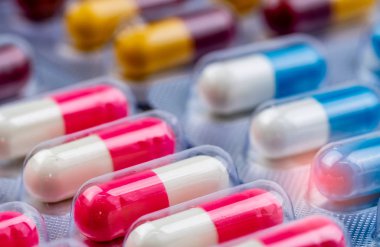 Kabarcık paketi pembe-beyaz antibiyotik kapsül hapları seçici odak. İlaç endüstrisi. Antibiyotik ilaç direnci kavramı. Hastanede tedavi enfeksiyonu için antimikrobiyal kapsül hapları.