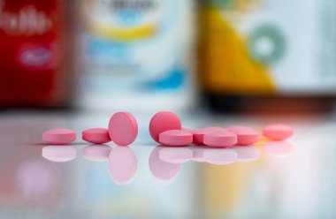 Uyuşturucu kutusu ve ilaç şişesi bulanık arka plan üzerinde pembe tablet hapları. Vitaminler ve takviyeleri tabletler. Eczane eczanesi. Farmasötik ürünler. Sağlık ve eczacılık. İlaç uzlaşılamak.