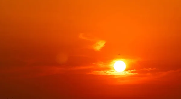 Dramático céu vermelho e laranja e nuvens fundo abstrato. Avião voando perto do sol grande no por do sol. Imagem de arte do céu ao anoitecer. Pôr do sol fundo abstrato. Companhia aérea comercial no voo da noite . — Fotografia de Stock
