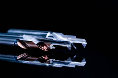 Siyah arka planda izole özel araçlar. Özel araçlar sipariş etmek için yapılmıştır. Kaplamalı adım matkap ve rayba detay. HSS Çimentolu karbür. Endüstriyel uygulamalar için karbür kesme aleti. Mühendislik araçları.