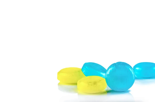 Medical lozenges for relief cough, sore throat and throat irritation isolated on white background. Cough and colds drop. Colorful cough pastille. Blue and yellow round candy or sweets. Menthol flavor.