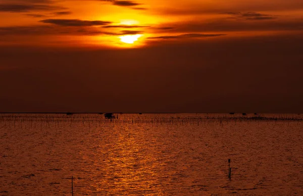 Гарний захід сонця над морем. Темне і золоте небо заходу і хмари. Природа тла для спокійного і мирної концепції. Захід сонця в Чонбурі, Таїланд. Художній малюнок неба у сутінках. Сільське господарство в морі. — стокове фото
