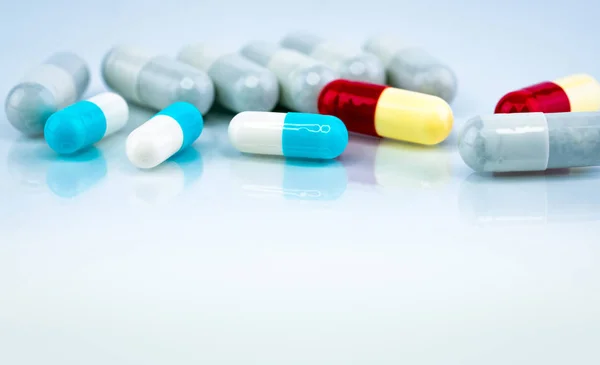 Színes kapszula tabletták fehér alapon. Gyógyszeripar. Növényi gyógyszer kölcsönhatás más gyógyszerekkel. Gyógyszerészet. Gyógyszertár gyógyszertár koncepció. Kék, fehér, piros és sárga kapszula pirulák. — Stock Fotó