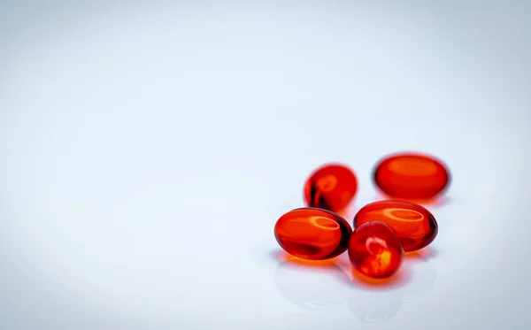 白い背景に分離された赤い柔らかいゲルカプセルの丸薬。赤色軟ゼラチンカプセルの山。ビタミンと栄養補助食品の概念。製薬業界。薬局ドラッグストア。ヘルスケア製品. — ストック写真