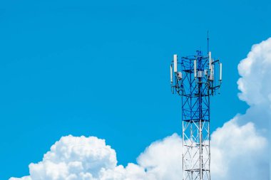 Telekomünikasyon kulesi mavi gökyüzü ve beyaz bulutlar arka planda. Mavi gökyüzünde anten. Radyo ve uydu direği. İletişim teknolojisi. Telekomünikasyon endüstrisi. Cep telefonu ya da telekom 4G ağı.