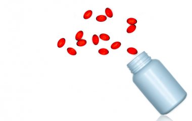 Beyaz arka plan üzerinde izole ilaç şişesi kırmızı yumuşak jel kapsül hapları dökün. Kırmızı yumuşak jelatin kapsül vitaminler ve diyet takviyeleri. İlaç endüstrisi. Eczane eczanesi. Sağlık.