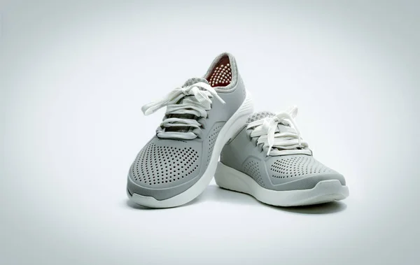 Ein Paar graue Schuhe auf weißem Hintergrund. bequeme Schuhe mit Poren. Atmungsaktive Gummischuhe. Schuhe. — Stockfoto