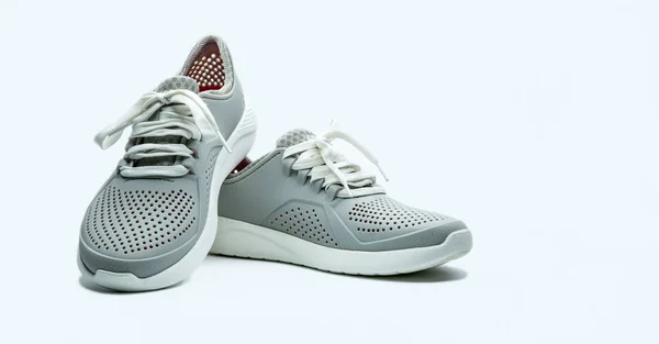 Ein Paar graue Schuhe auf weißem Hintergrund. bequeme Schuhe mit Poren. Atmungsaktive Gummischuhe. Schuhe. — Stockfoto