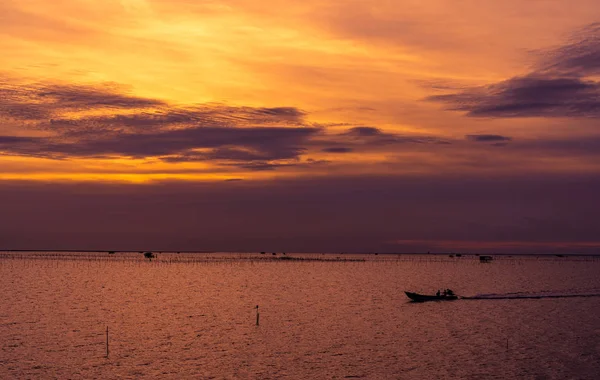 Magnifique coucher de soleil spectaculaire. Ciel sombre et orangé couchant et nuages. Fond naturel pour un concept tranquille et paisible. Mer tropicale au crépuscule. Bateau à longue queue naviguant par pêcheur. Beauté dans la nature . — Photo