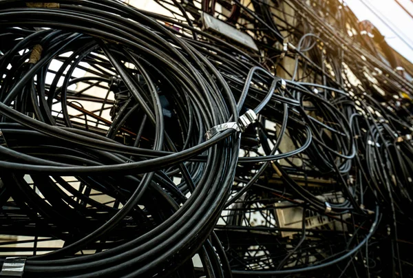 Kabel listrik tersangkut di tiang listrik perkotaan. Tidak teratur dan berantakan untuk konsep manajemen organisasi. Kabel listrik kusut dari dekat. Harus mengambil kabel bawah tanah untuk pemandangan yang indah . — Stok Foto