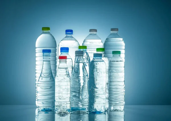 Set de botella de agua de plástico transparente con etiqueta en blanco. Botella de agua clara y mineral natural con tapa blanca, verde, roja y azul. Bebida saludable. Colección de frasco de plástico con líquido completo . — Foto de Stock