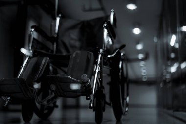 Geceleri hastanenin koridorunda servis hastaları ve engelliler için tekerlekli sandalye bulanıklığı. Engellilere yardım için hastanede tıbbi malzemeler var. Hasta bakımı için tekerlekli sandalye.