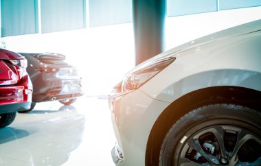 Modern galeride park edilmiş lüks SUV arabası. Galeride kırmızı, beyaz ve gri SUV var. Araba galerisi konsepti. Otomotiv endüstrisi. Elektrikli araba işi ve teknoloji. Modern sergi salonu..
