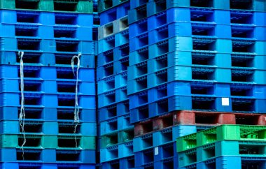 Plastik nakliye paleti yığını. Fabrika deposuna istiflenmiş endüstriyel plastik palet. Kargo ve nakliye konsepti. İhracat endüstrisi için plastik palet rafı. Plastik palet deposu.