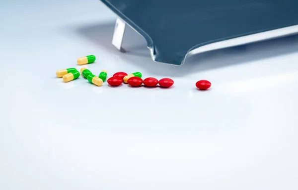 Czerwone Tabletki Zielono Żółte Kapsułki Tacą Białym Stole Przemysł Farmaceutyczny — Zdjęcie stockowe