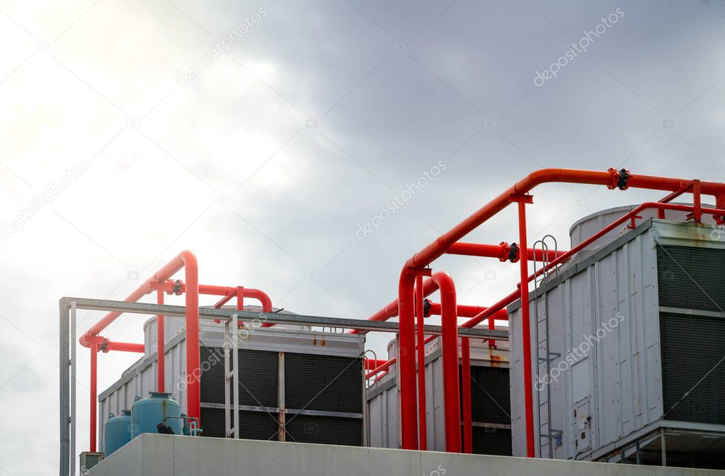 Cooling tower on roof top of building. Industrial air cooling system. Air chiller. Unit of air conditioner. Air cooled chiller with piping system on rooftop of building. Cooling tower outside building