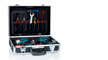 Alet kutusu beyaz arkaplanda izole edildi. Aletleri olan siyah alet çantası. Kerpeten, İngiliz anahtarı, tornavida, kesici ve kablosuz sürücü matkabı. Becerikli bir alet çantası. Tamirci el aletleri. 