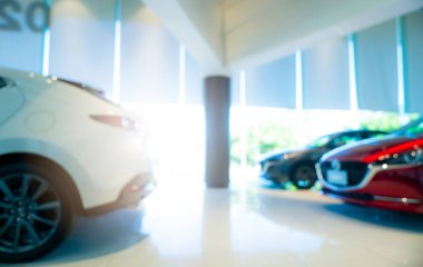 Modern sergi salonuna park edilmiş bulanık kırmızı ve beyaz bir araba. Araba galerisi ve oto kiralama konsepti. Otomotiv endüstrisi. Modern lüks sergi salonu. Galeriye park edilmiş yeni bir araba. Elektrikli otomobil teknolojisi. 