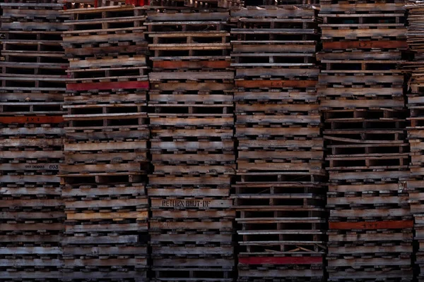 Pile of old wooden pallet. Industrial wood pallet stacked at factory warehouse. Cargo and shipping concept. Wood pallet rack for export delivery industry. Wooden pallet storage warehouse of factory.