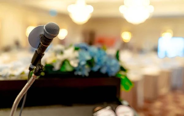 Microphone on stand at podium stage for public speaking or speech in conference hall. Mic for speaker on stage of event. Meeting and presentation in seminar room. Microphone for talking to audience.