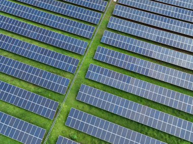 Hava manzaralı güneş çiftliği. Yeşil enerji için güneş enerjisi. Sürdürülebilir yenilenebilir enerji. Fotovoltaik güç istasyonu. Güneş paneli kurulumu. Enerji sürdürülebilirliği. Çevre dostu elektrik üretimi.