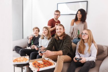 Grup neşeli arkadaşıyla birlikte süre iskambil video spor, pizza yemek ve evde bira içmeye vakit 