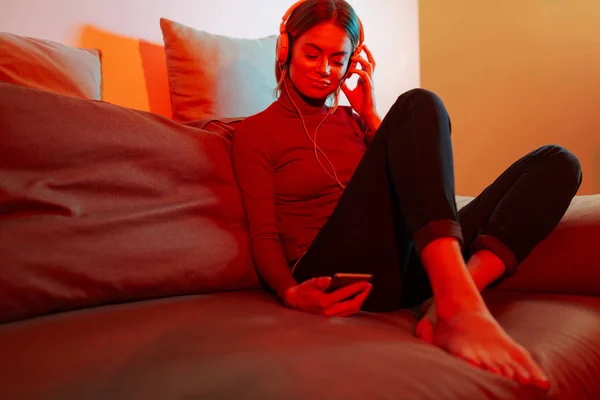 Kanepede Oturan Dinleme Müzik Kulaklık Cep Telefonu Evde Eller Genç — Stok fotoğraf