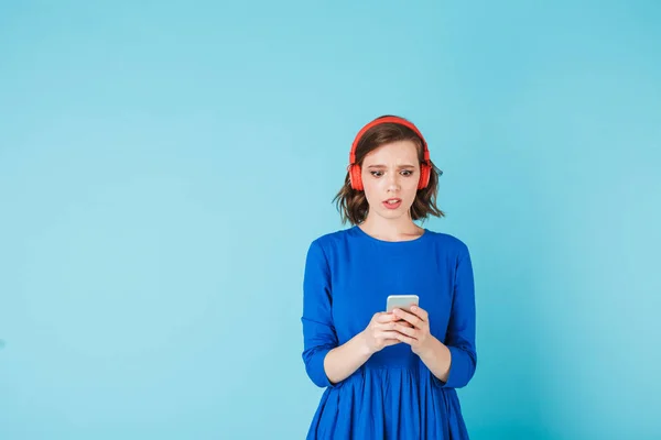 Foto Una Joven Escopeta Vestido Auriculares Rojos Pie Asombradamente Mirando —  Fotos de Stock