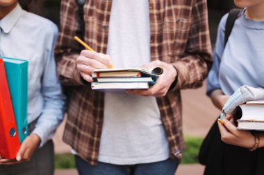 Kalem ve kitap elinde tutan gencin fotoğraf kapatmak