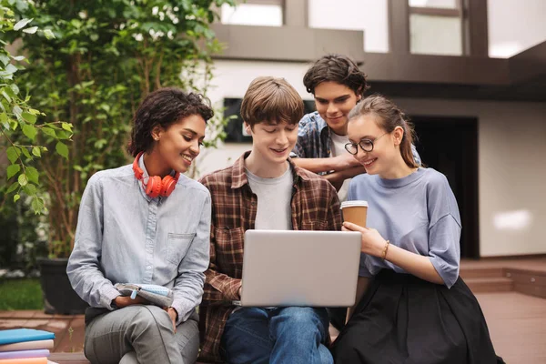 Gruppe Unge Smilende Studenter Som Sitter Benken Jobber Med Laptop – stockfoto