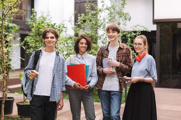 Grupa Młodych Studentów Uśmiechający Się Stojąc Książek Foldery Ręce Szczęśliwie — Zdjęcie stockowe