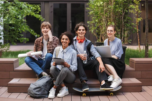 Grupo Estudantes Sorrindo Legal Sentado Olhando Alegremente Para Câmera Enquanto — Fotografia de Stock