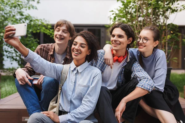 Gruppo Studenti Allegri Seduti Scattare Foto Carine Sul Cellulare Mentre — Foto Stock