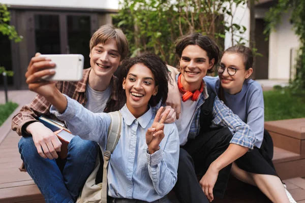 Grupo Jovens Estudantes Alegres Sentados Tirando Fotos Fofas Celular Enquanto Fotos De Bancos De Imagens Sem Royalties