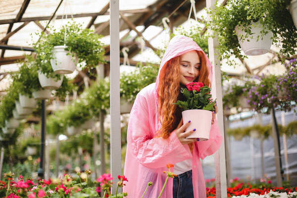 Beautiful Lady Redhead Curly Hair Standing Pink Raincoat Dreamily Smelling Stock Image