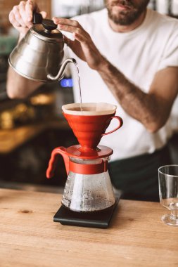 Kasada duran ve kafede kahve üzerine dökün hazırlanıyor barista fotoğrafı kapatın