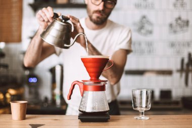 Kasada duran ve kafede kahve üzerine dökün hazırlanıyor barista fotoğrafı kapatın