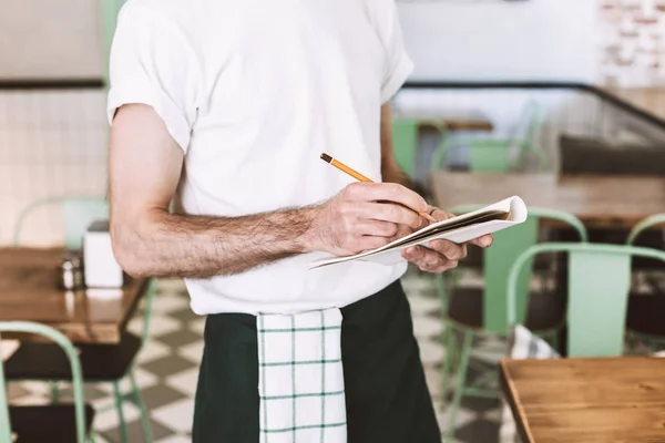 Foto Ravvicinata Del Cameriere Piedi Con Matita Scrittura Ordine Notebook — Foto Stock