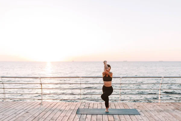 Foto Vakker Dame Som Står Trener Yoga Positurer Ved Havet – stockfoto