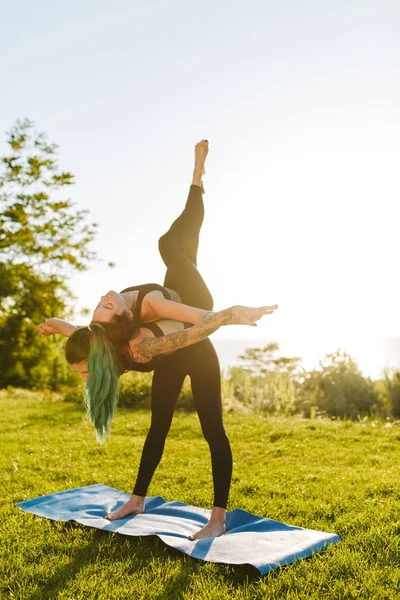Две Дамы Черных Спортивных Топах Леггинсы Тренирующие Йогу Позируют Вместе — стоковое фото