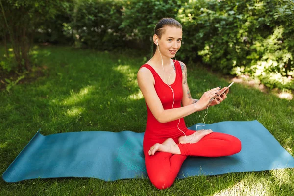 Cantik Tersenyum Wanita Dalam Jumpsuit Merah Duduk Teratai Berpose Yoga — Stok Foto