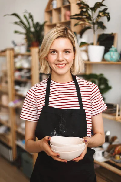 Lachende Meisje Zwarte Schort Gestreept Shirt Bedrijf Handgemaakte Kommen Handen — Stockfoto