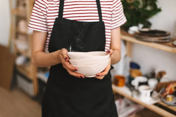 Close Van Meisje Houdt Van Handgemaakt Kommen Handen Zwarte Schort — Stockfoto