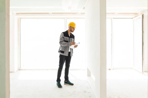 Young Engineer Work Clothes Yellow Hardhat Holding Plan New Apartments — Stock Photo, Image