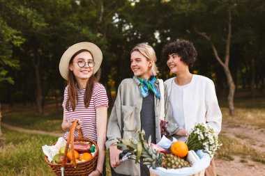 Tam mutlu kamera iki kız ise sevinçle ona baktığını parkta bisiklet seyir ile meyve sepeti tutan güzel kız