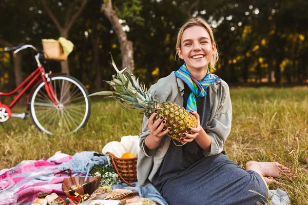 Joyful Girl Sitting Picnic Blanket Grass Happily Holding Pineapple Hands — Stock Photo, Image