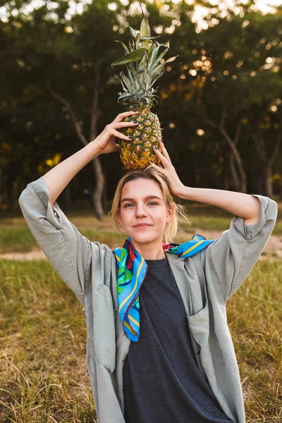Güzel kız şakacı sersem park piknik üzerinde kamera harcama zaman seyir kafasına ananas holding